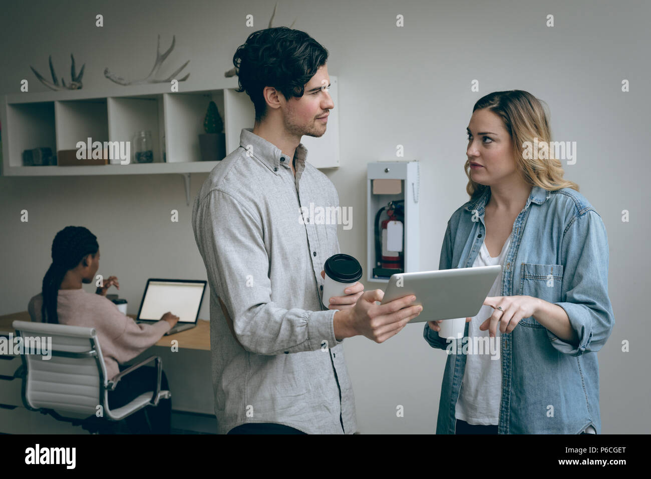 Executives discussing over digital tablet Stock Photo