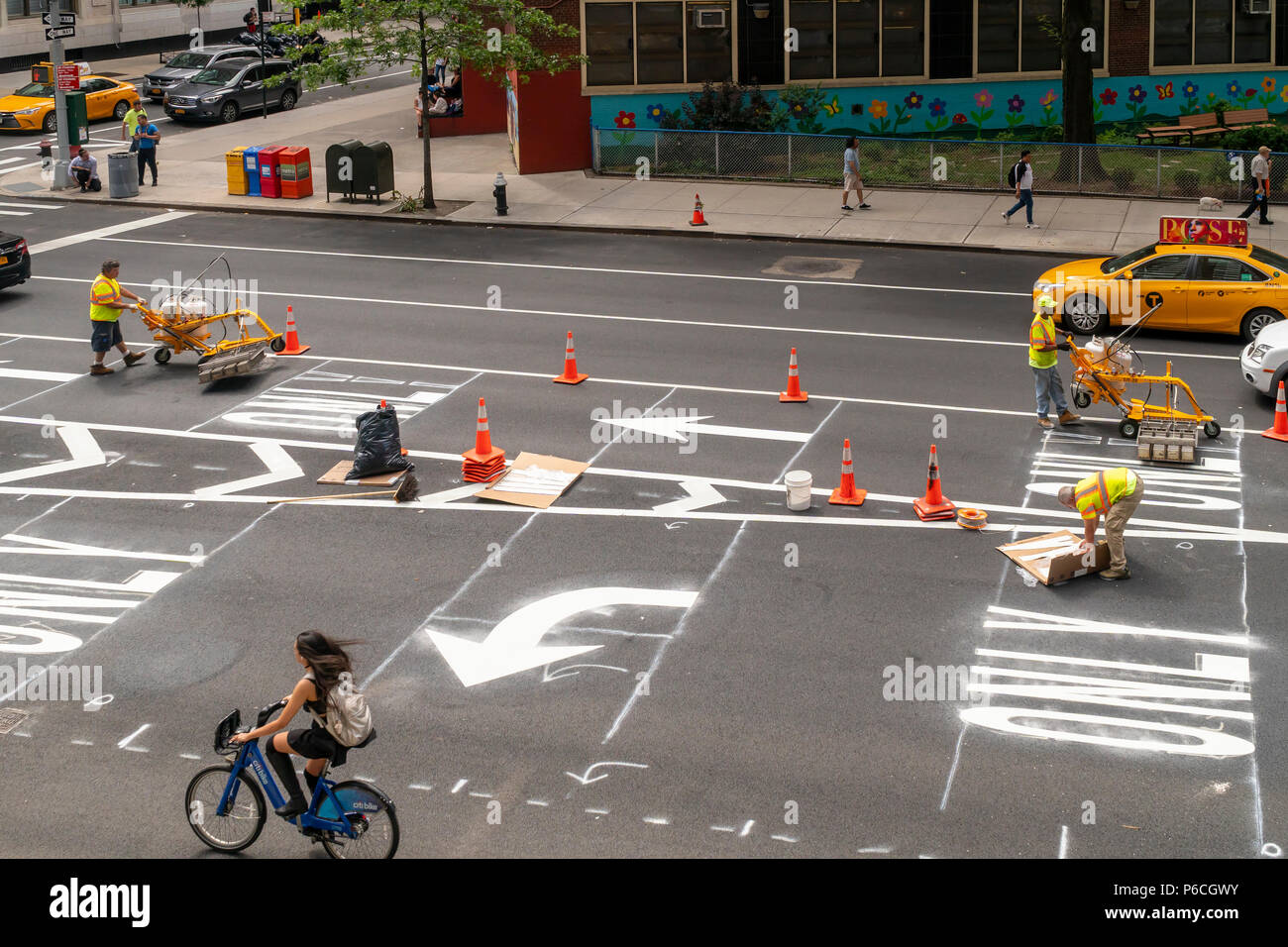 Employees from the New York City Department of Transportation install new thermoplastic lane markings after a recent re-paving on Ninth Avenue in the Chelsea neighborhood of New York on Wednesday, June 20, 2018.  (Â© Richard B. Levine) Stock Photo