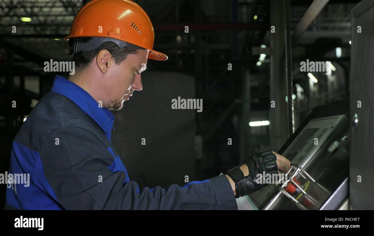 Operator monitors control panel of production line. Manufacture of plastic water pipes of the