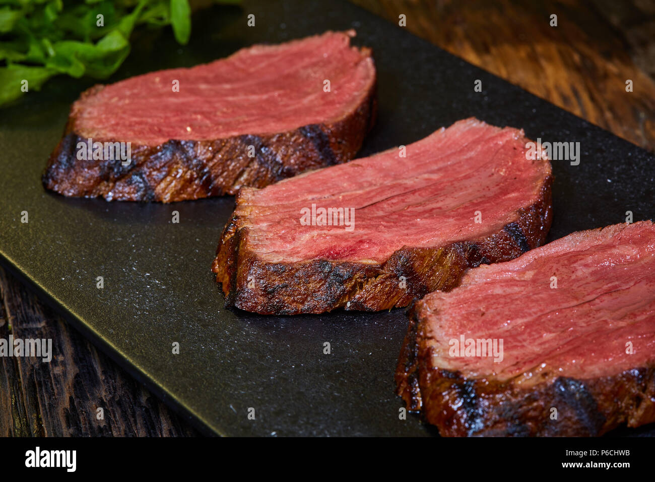 Sousvide steak cut into pieces, cooked to eat beef on the stone table. Shallow dof Stock Photo