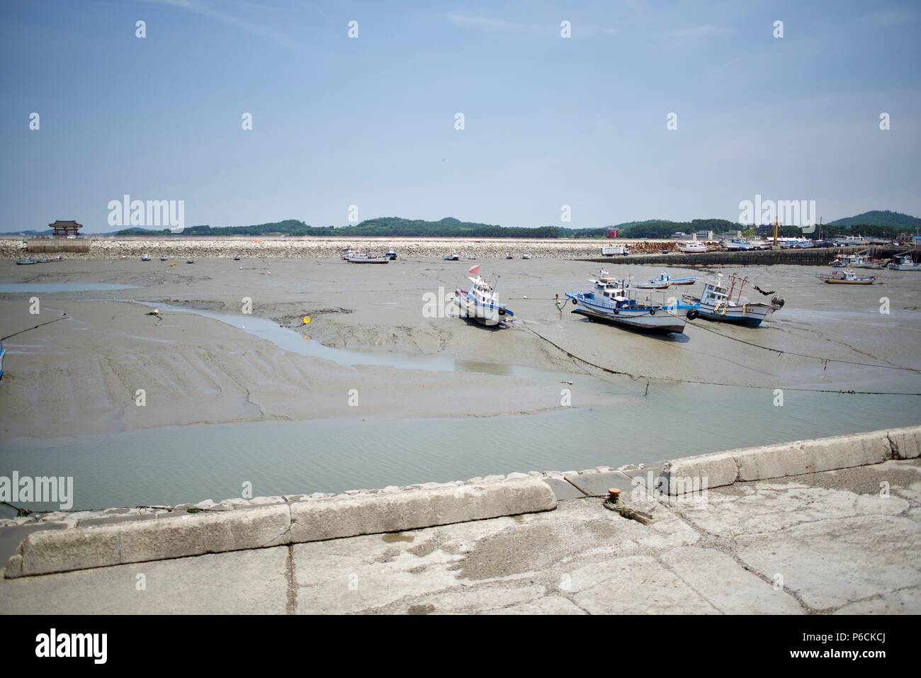 It is the summer scene of a fishing village in Korea. The low tide mudflat broke out, and the ship stopped. Stock Photo