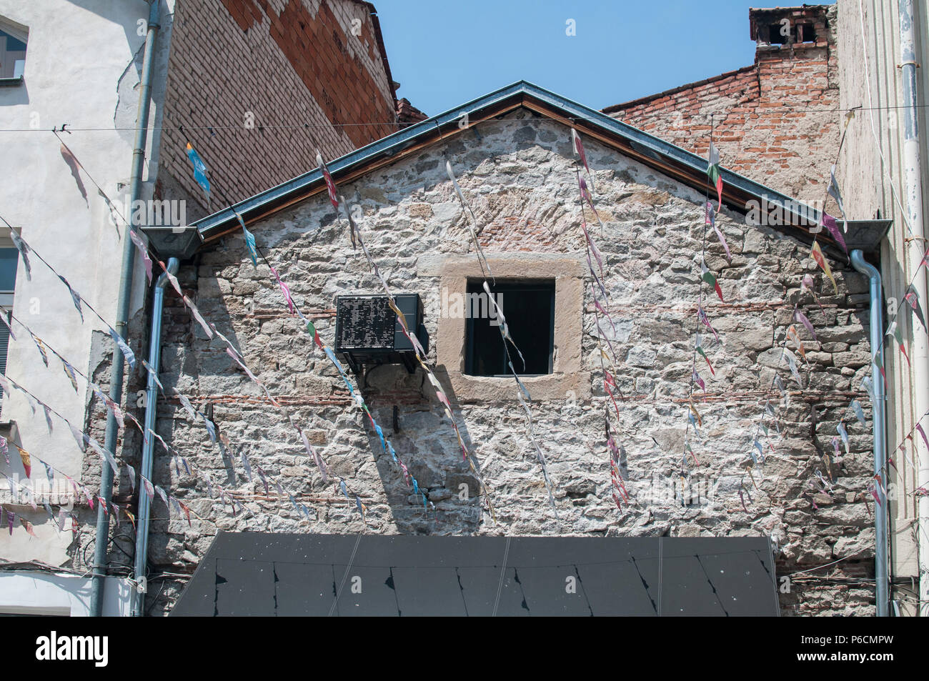 Old stone house facade wall with small window and obsolete air ...