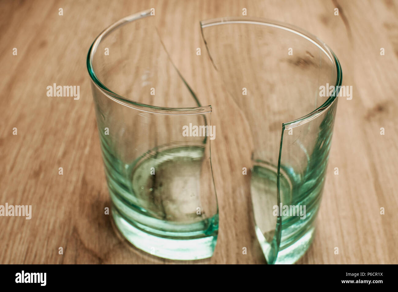 Broken transparent glass cup in two symmetrical parts closeup Stock