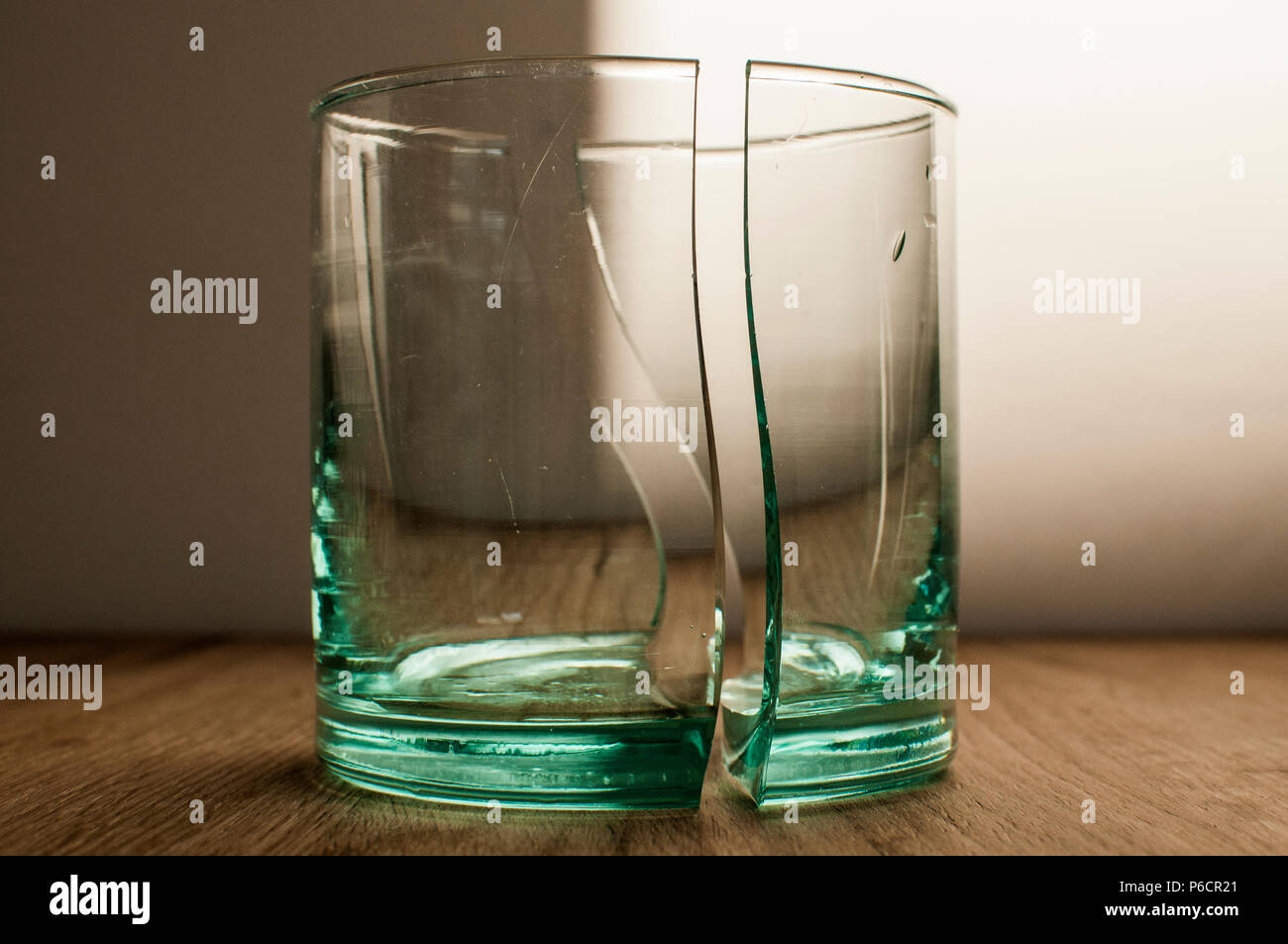 Broken transparent glass cup in two symmetrical parts closeup Stock
