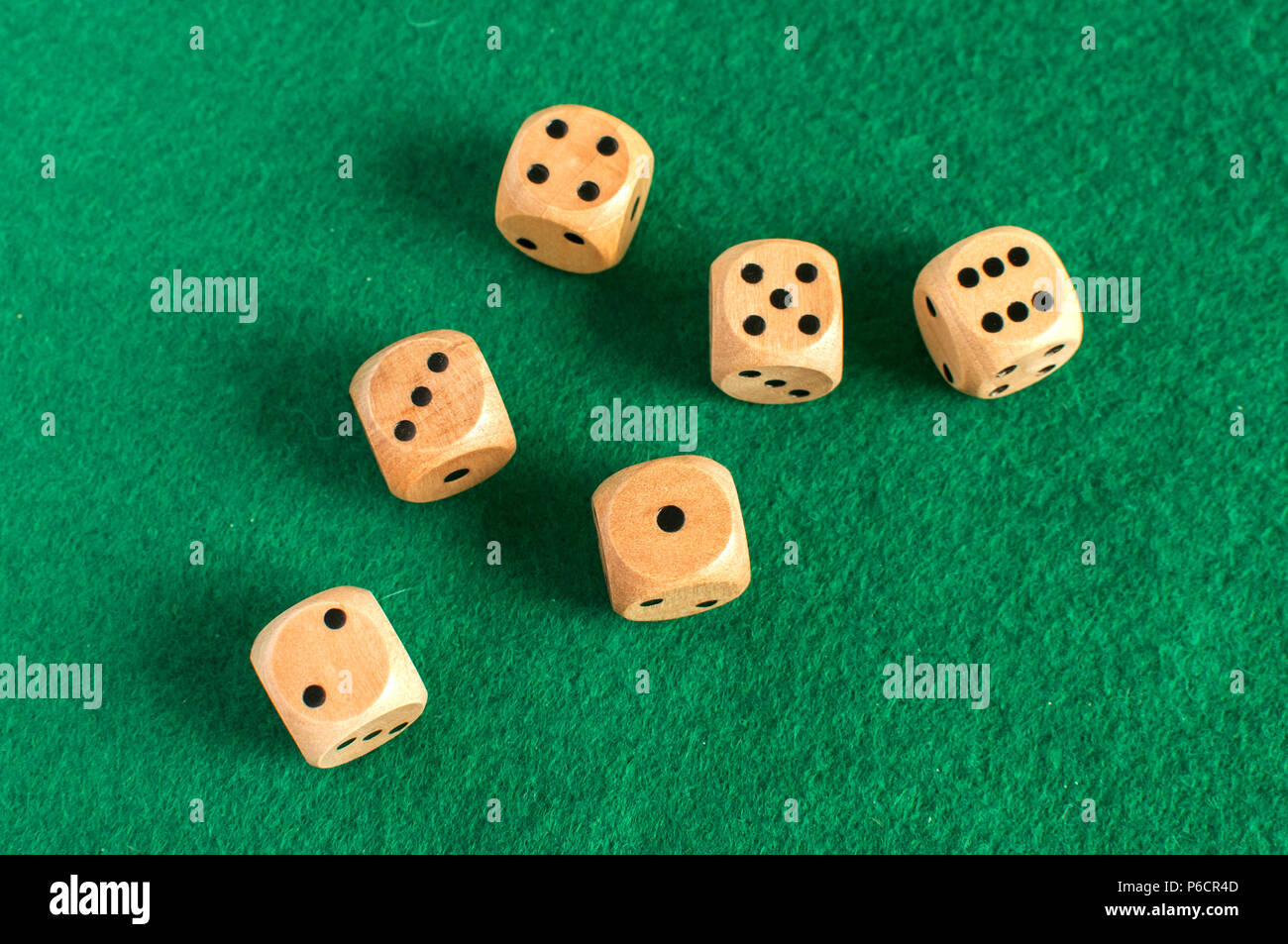 Wooden round corner dice six sided dots set for playing on dark green