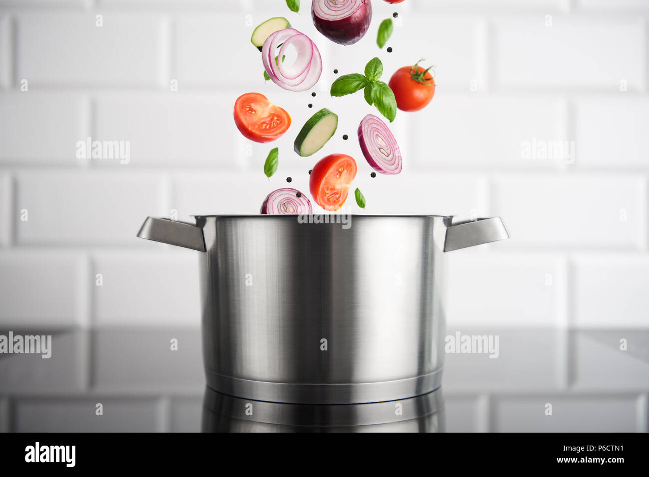 https://c8.alamy.com/comp/P6CTN1/healthy-eating-stainless-steel-pot-with-vegetables-on-the-induction-stove-with-white-metro-tiles-in-the-background-high-resolution-horizontal-P6CTN1.jpg
