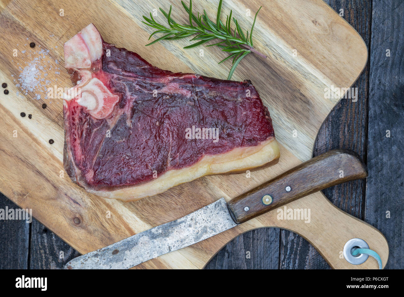 Dry aged T-bone steak raw on a wooden board. Stock Photo