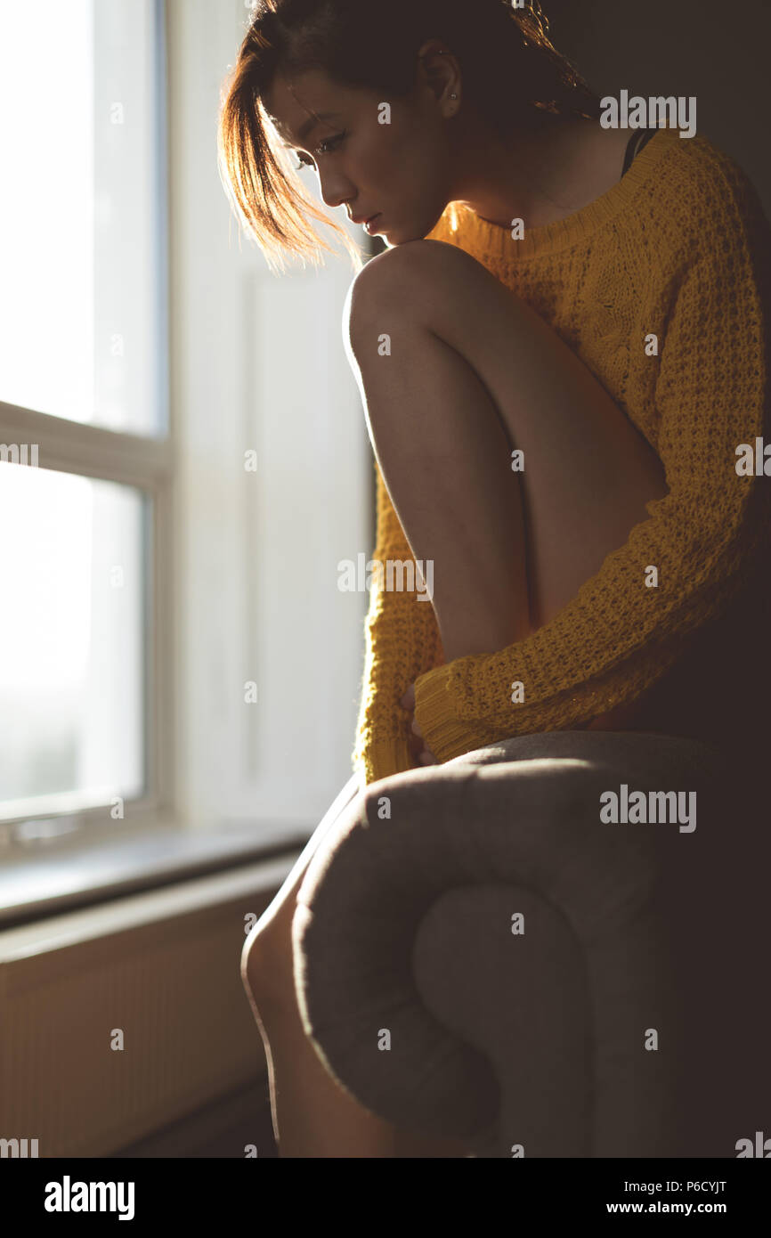 Woman relaxing near window at home Stock Photo