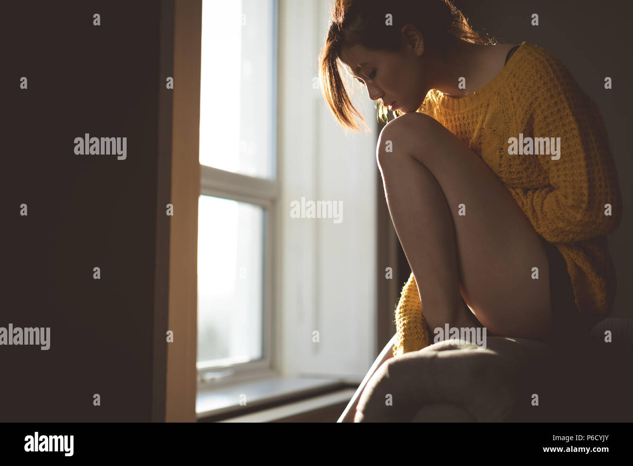 Woman relaxing near window at home Stock Photo