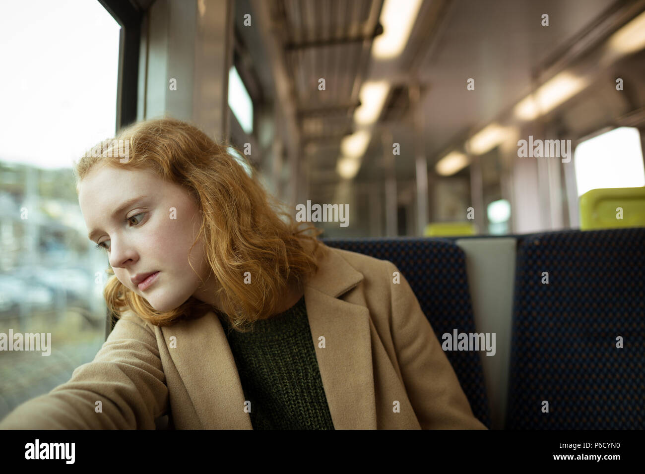 Red hair young woman looking outside the window Stock Photo
