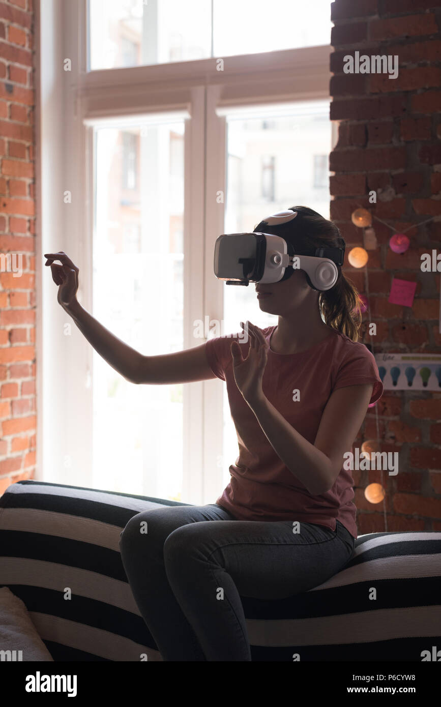 Female executive using virtual reality headset Stock Photo - Alamy