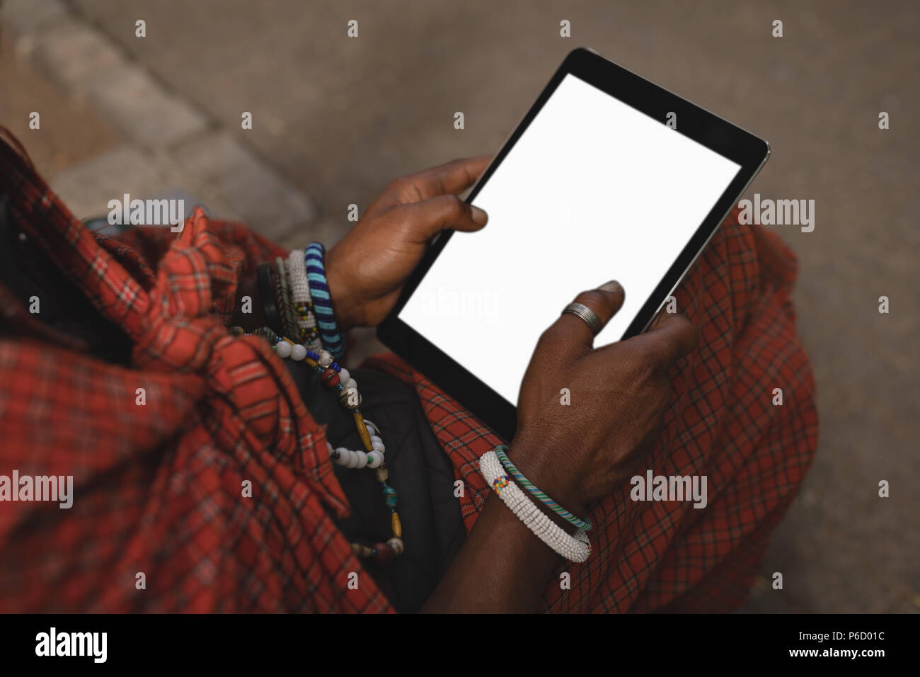 Maasai man in traditional clothing using digital tablet Stock Photo