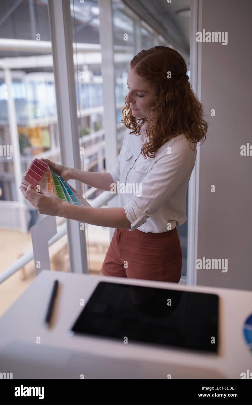 Female graphic designer looking at color swatch book Stock Photo
