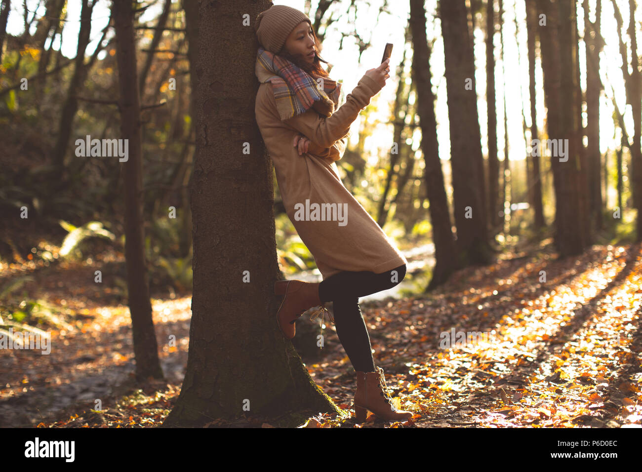 Beautiful woman in warm clothing using mobile phone Stock Photo