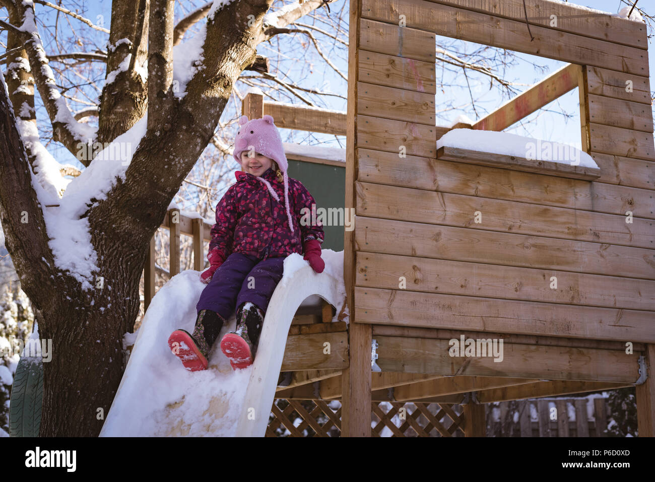 Cute girl playing in snow covered playground Stock Photo