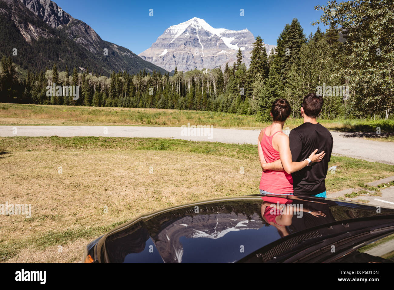 Couple looking at snow capped mountains Stock Photo