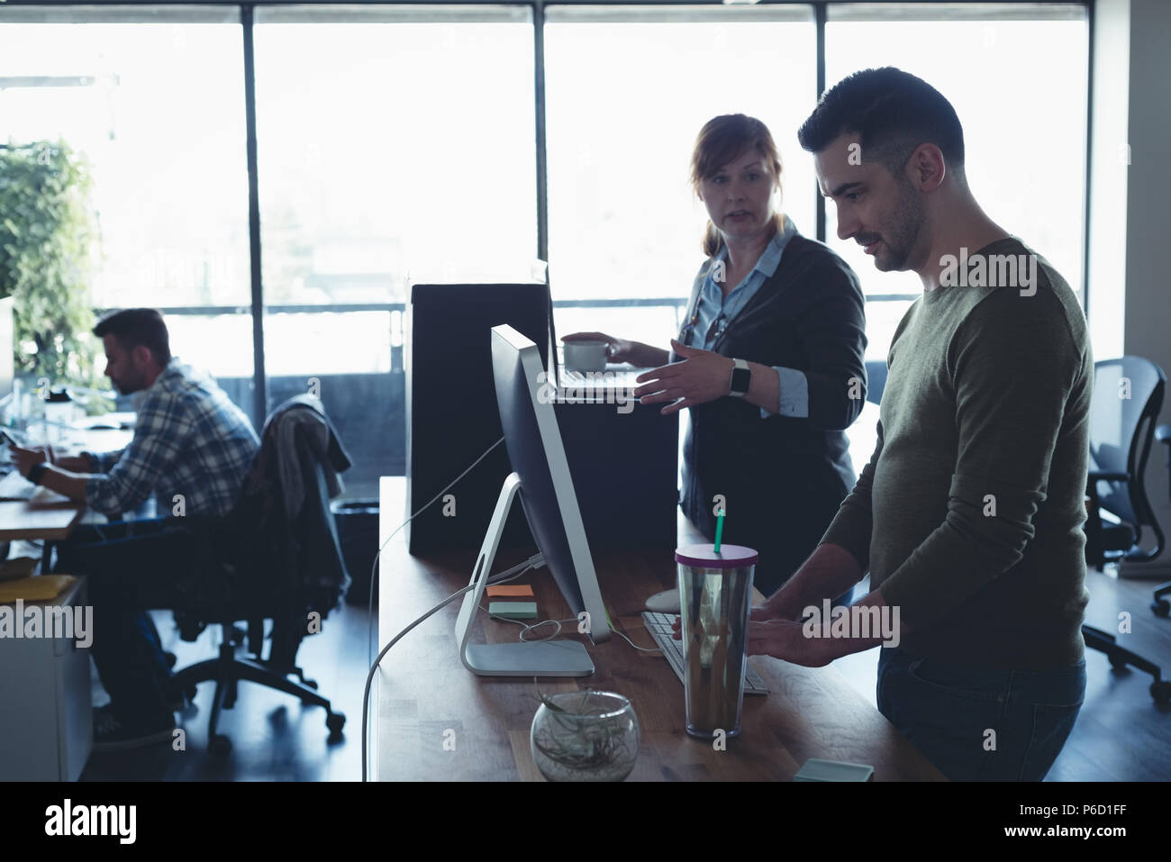 Business colleagues interacting with each other while working Stock Photo