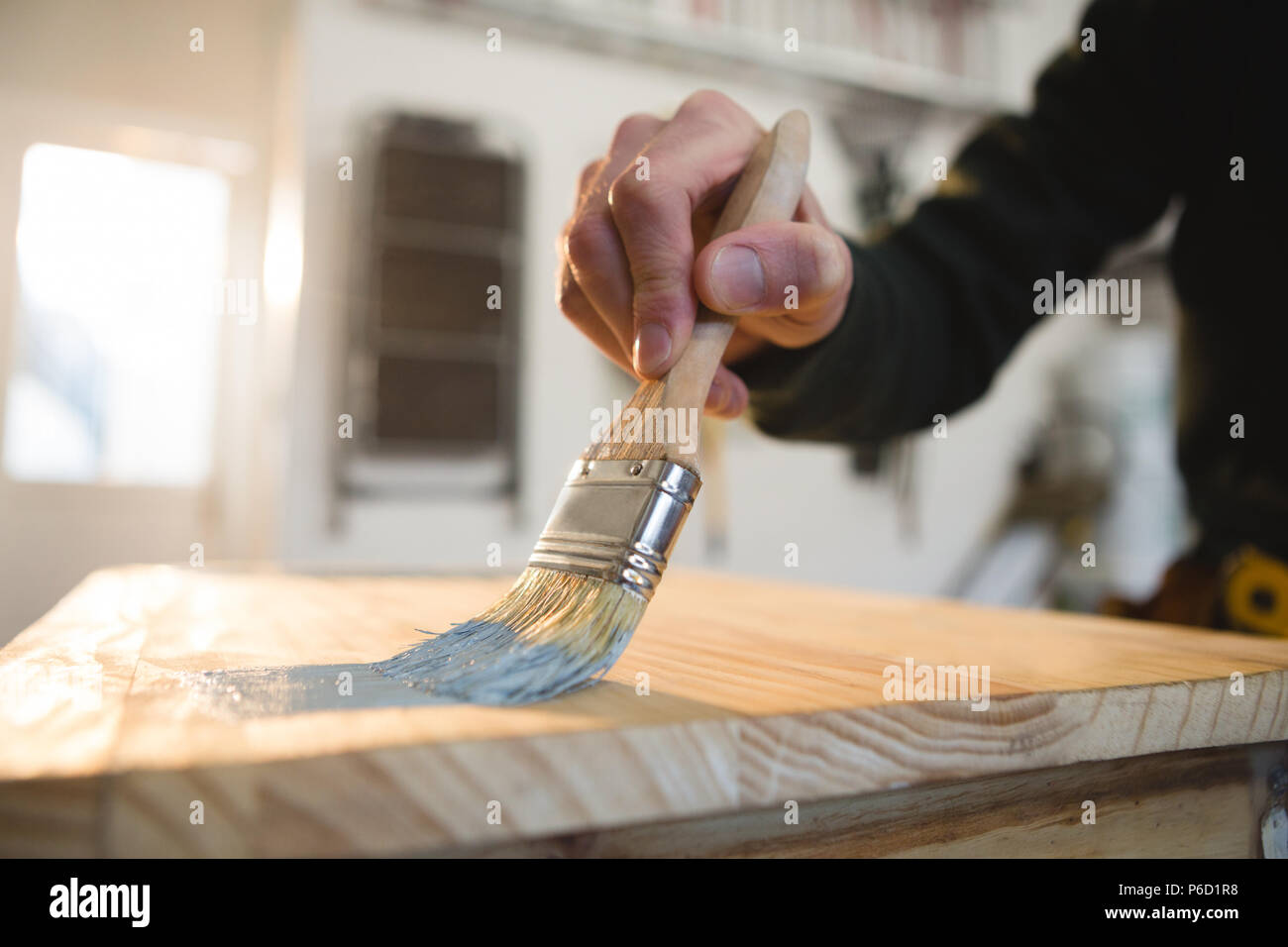 Male carpenter painting a table Stock Photo