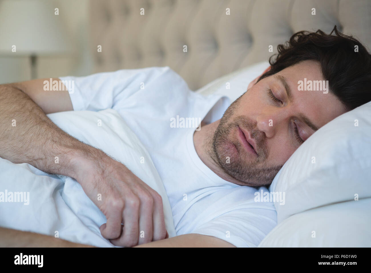 Man sleeping in bedroom Stock Photo