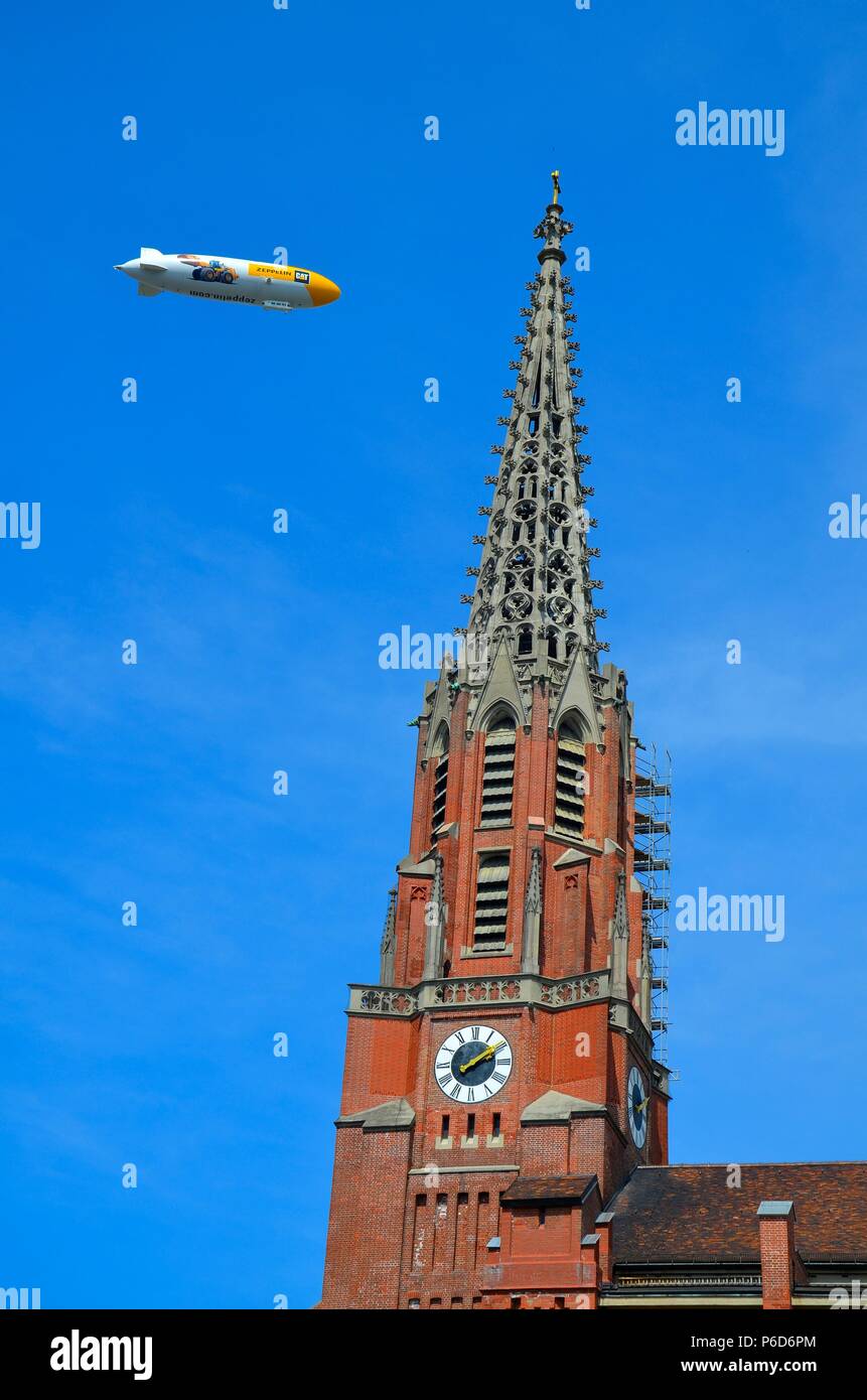 Munich, the capital of Bavaria (Germany): the church 'Mariahilfkirche in der Au' and a Zeppelin Stock Photo