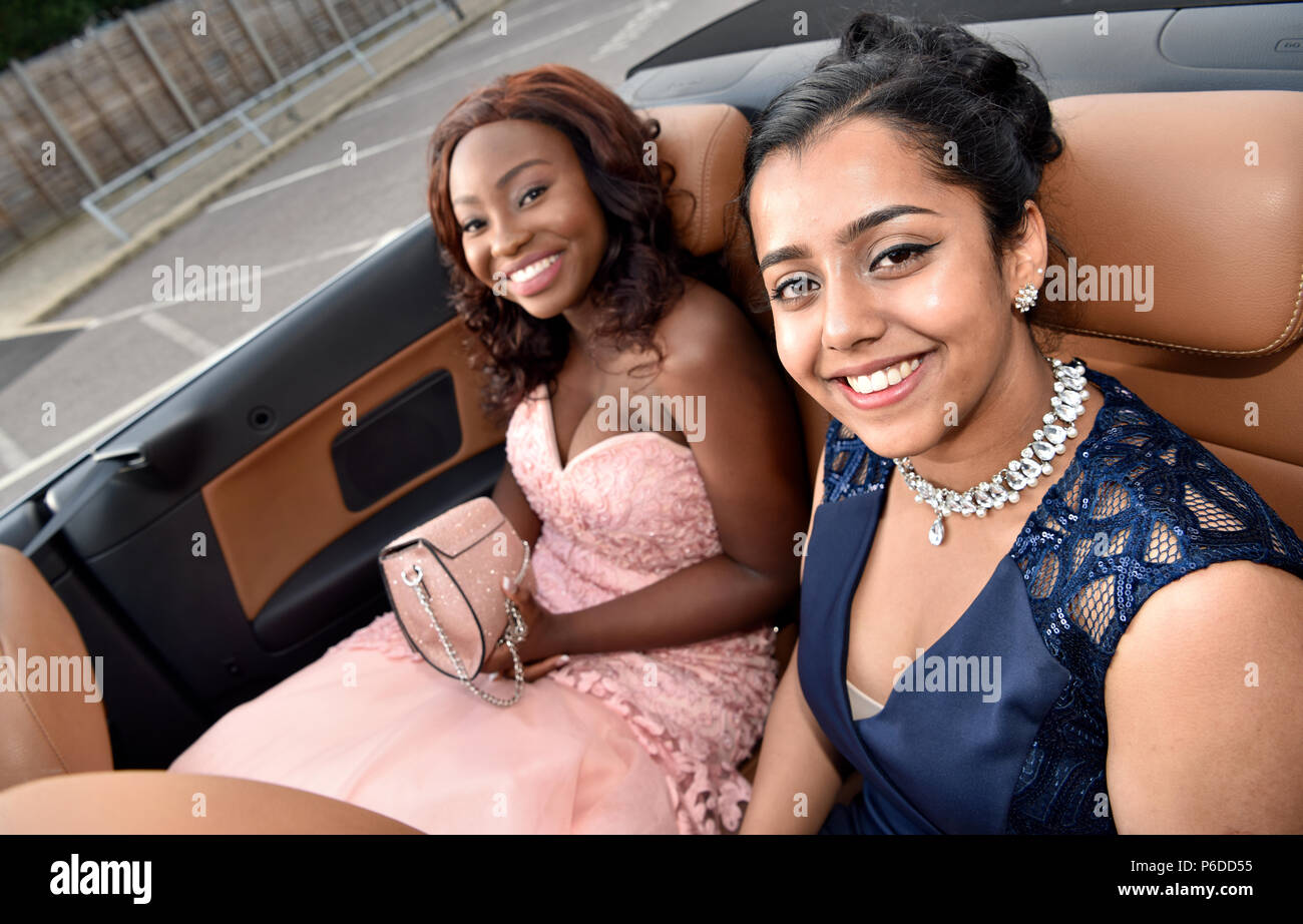 Female pupils dressed in their finery arriving in a limo for their School Prom, Farnham, Surrey, UK. 22 June 2018. Stock Photo