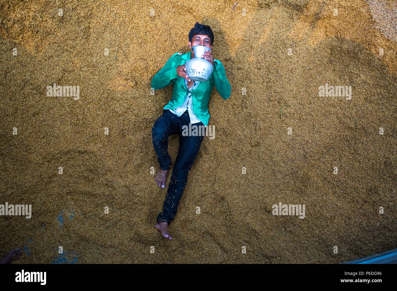 A rice mill worker drinking water at Ishwardi, Pabna District, Bangladesh. Stock Photo