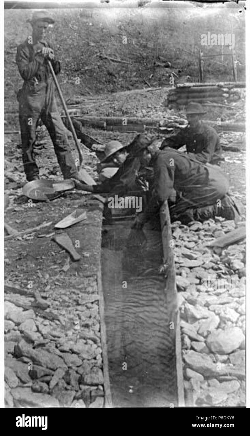 . English: Mining operation showing four men with gold pan and sluice, Bonanza Creek, 1898 . English: On verso of image: Cleaning up on #5 below Bonanza. 1898 PH Coll 35.486 Klondike Gold Rush Subjects (LCTGM): Gold mining--Yukon; Gold miners--Yukon; Sluices Subjects (LCSH): Gold mines and mining--Yukon; Gold panning--Yukon  . 1898 63 Mining operation showing four men with gold pan and sluice, Bonanza Creek, 1898 (SARVANT 207) Stock Photo