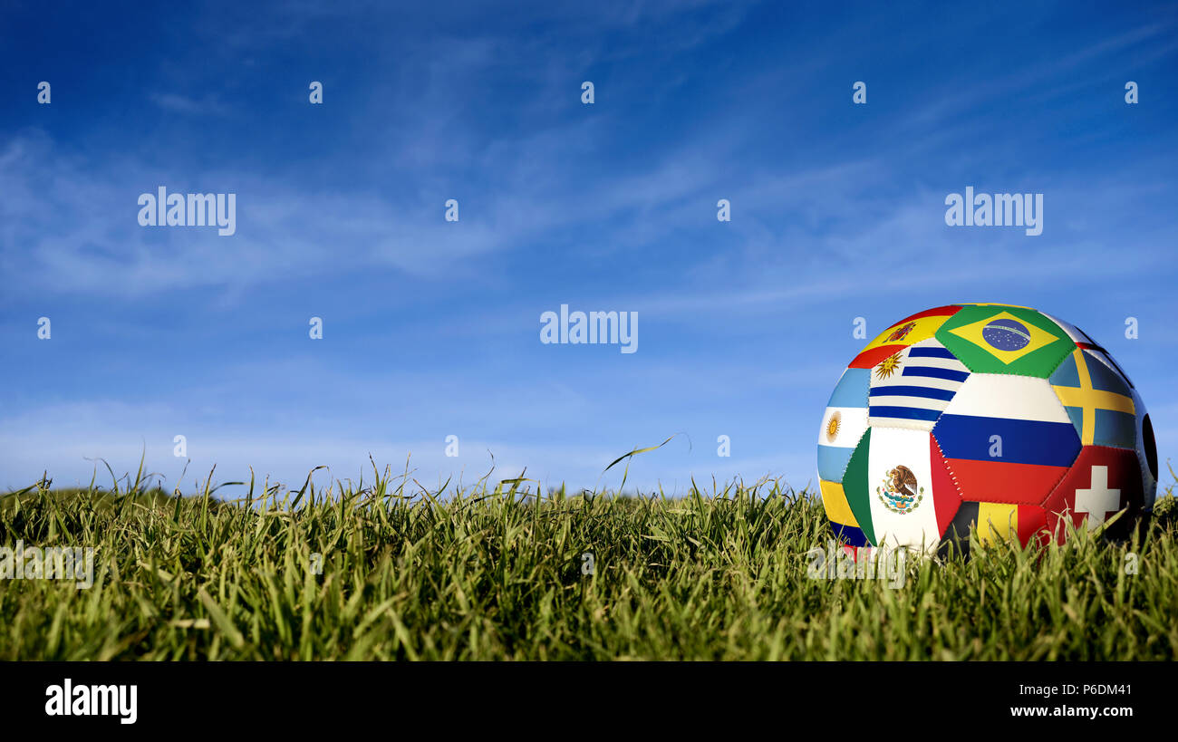 Soccer ball with international country flag of russian sport event groups. Realistic football on grass field over blue sky background. Includes russia Stock Photo