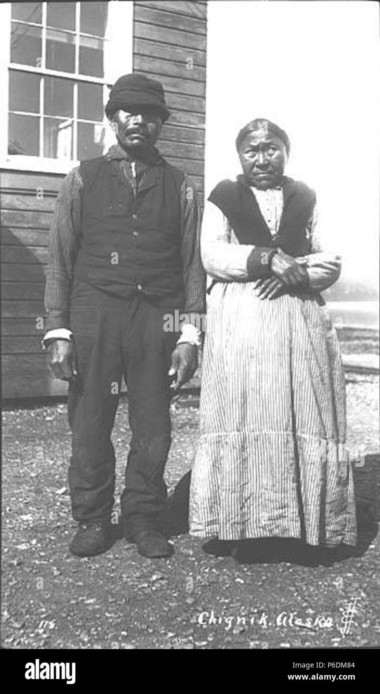 . English: Native couple, Chignik, ca. 1912 . English: Caption on image: Chignik, Alaska PH Coll 247.33 The City of Chignik is located on Anchorage Bay on south shore of the Alaska Peninsula, 450 miles southwest of Anchorage and 260 miles southwest of Kodiak. Prior to Chignik, a Kaniagmuit Native village called Kaluak was located here; it was destroyed during the Russian fur boom in the late 1700s. Chignik, a Sugpiaq word meaning 'big wind' was established in the late 1800s as a fishing village and cannery. A four-masted sailing ship called the 'Star of Alaska' transported workers and supplies Stock Photo