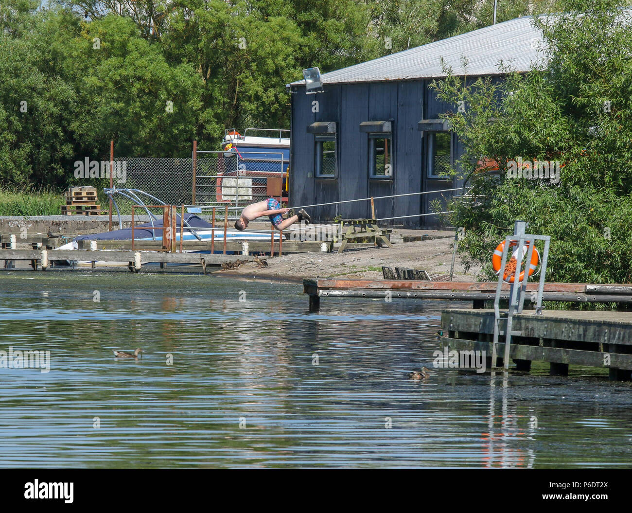Lough Neagh, Northern Ireland. 29 June 2018. UK weather - another glorious summer day as the heatwave continues. Lough Neagh is the UK's largest freshwater lake and with weather like this it's a great place to enjoy the best summer in decades. A young man diving into the water at Kinnego marina. Credit: David Hunter/Alamy Live News. Stock Photo