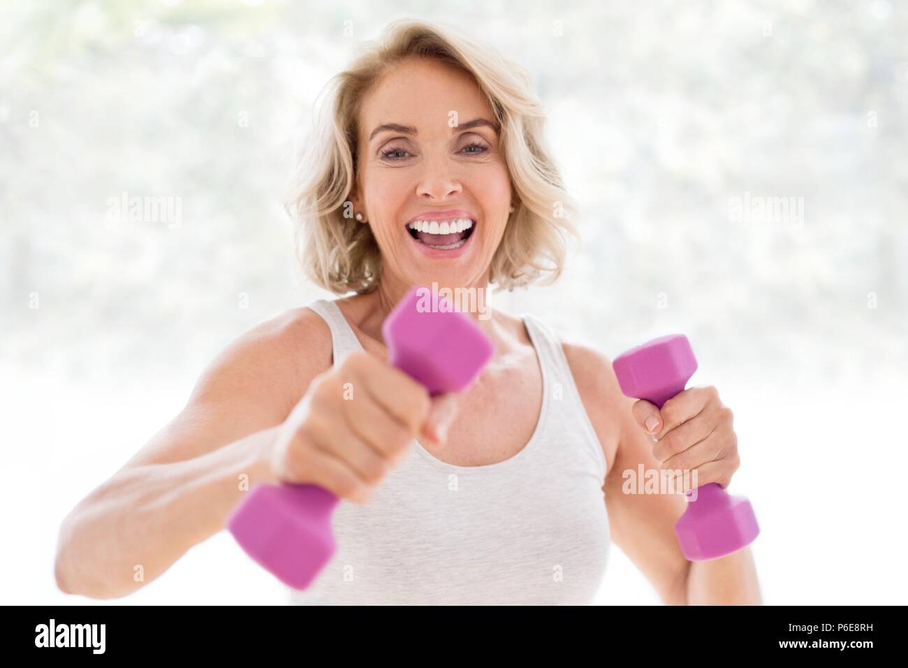 Mature woman using hand weights. Stock Photo