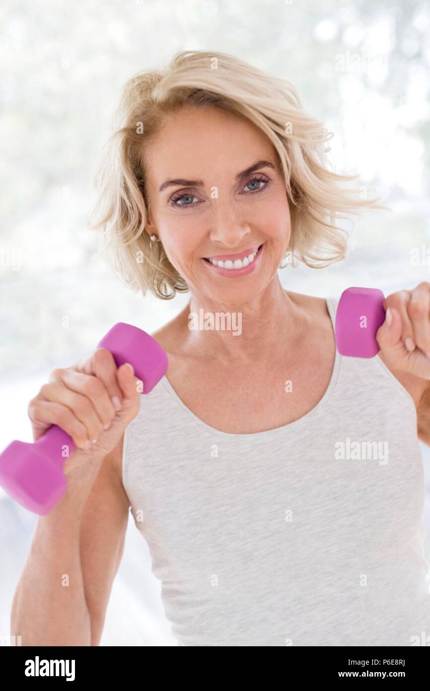 Mature woman using hand weights. Stock Photo