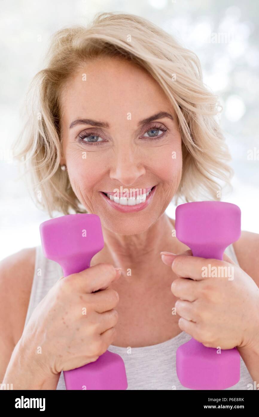Mature woman using hand weights. Stock Photo