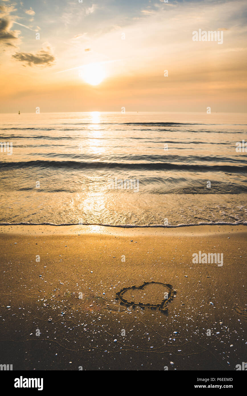 A Drawing Of A Heart On A Yellow Sand With A Beautiful Sunrise Seascape Background Stock Photo Alamy