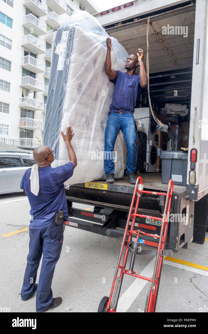 Miami Beach Florida,mattress delivery truck,Black Blacks African Africans ethnic minority,adult adults man men male,delivering,unloading,dolly,manual Stock Photo