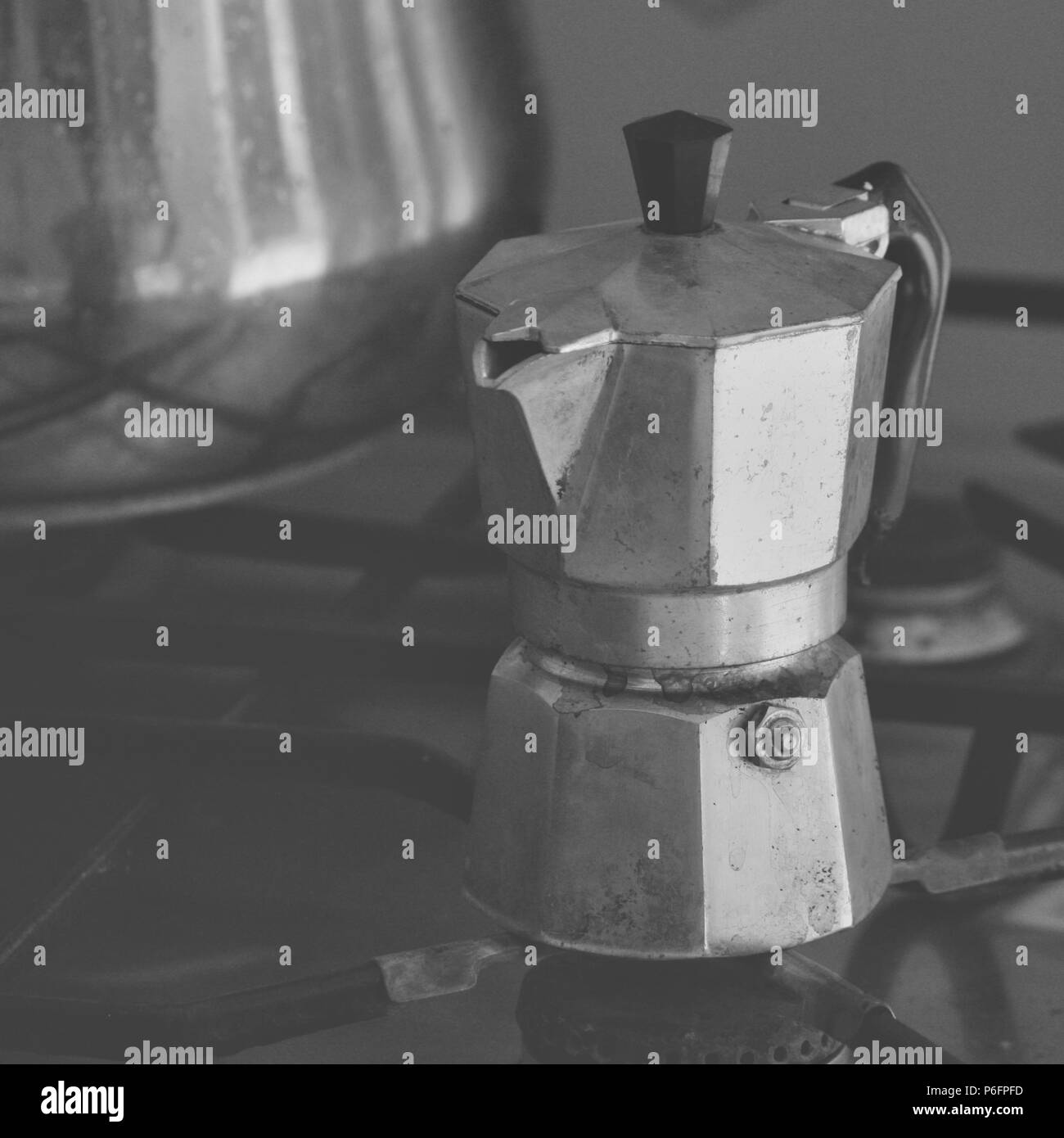 Old Stained Italian Moka on the stove in black and white Stock Photo