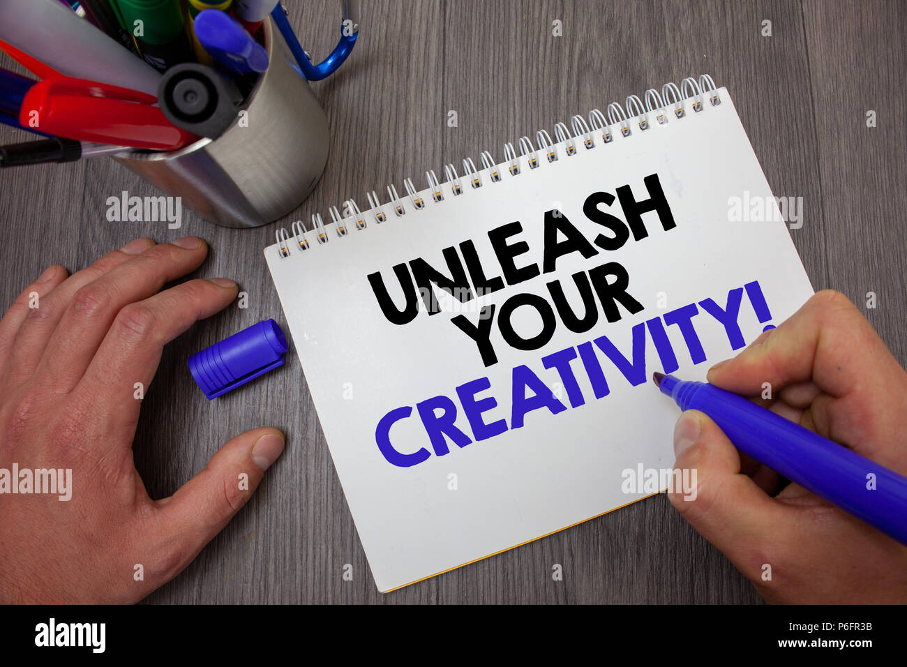 Text sign showing Unleash Your Creativity Call. Conceptual photo Develop Personal Intelligence Wittiness Wisdom Man hold holding blue marker notebook  Stock Photo