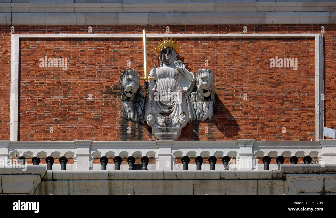Justice between the Venetian lions on the façade of the tower of St Mark's bell tower in the Piazza San Marco, Venice, Italy Stock Photo