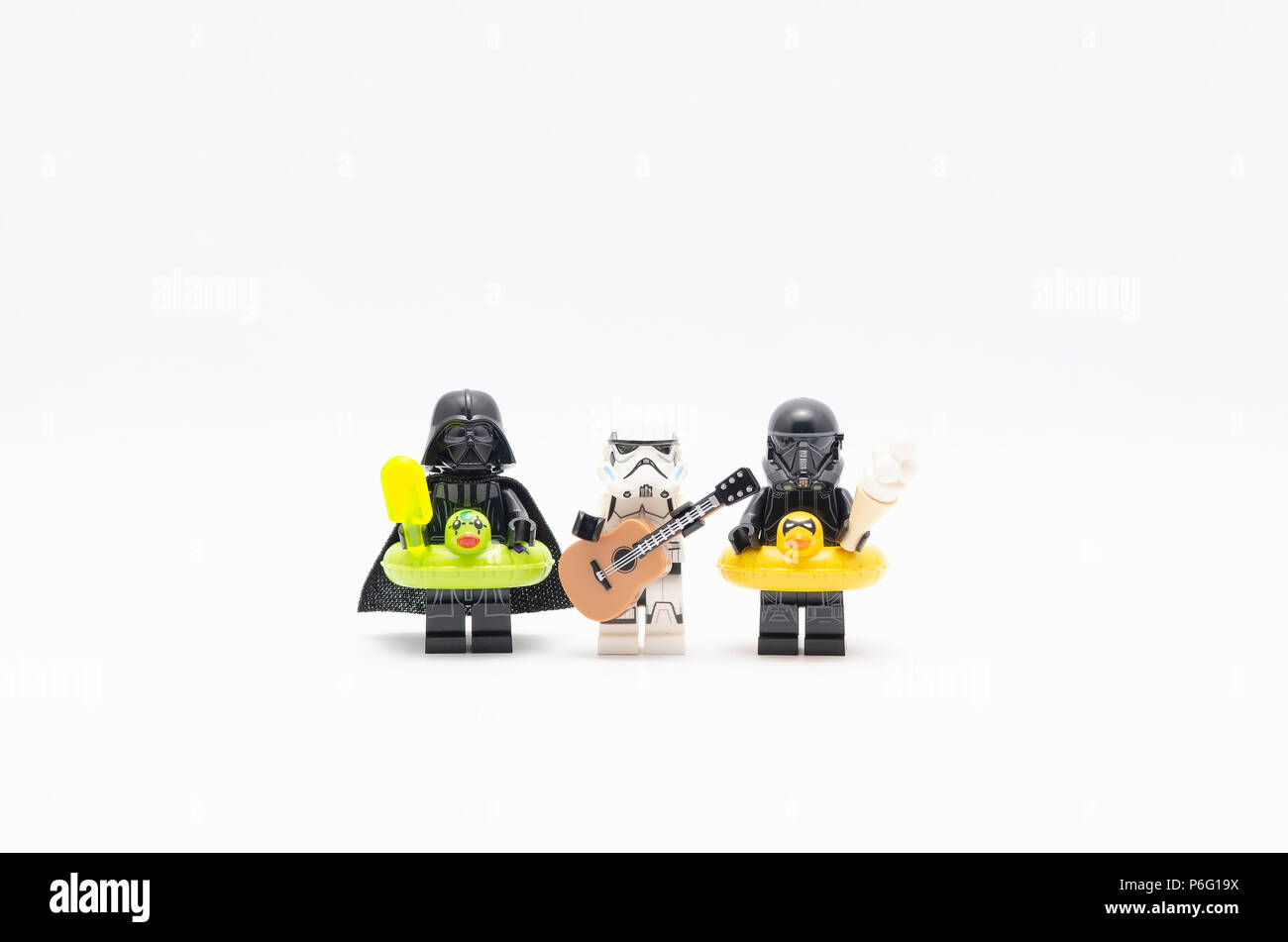 mini figure of  darth vader with storm trooper holding guitar and death trooper holding ice cream. Lego minifigures are manufactured by The Lego Group Stock Photo