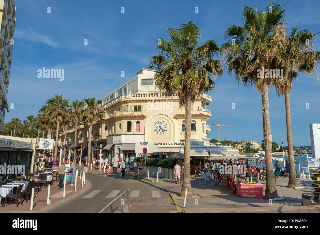 Shops, restaurants and palm trees along the seafront of Juan les Pins,  Antibes, France Stock Photo - Alamy