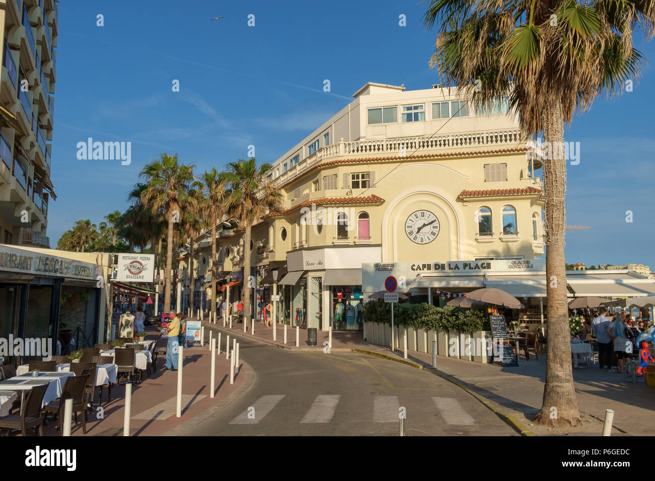 Shops, restaurants and palm trees along the seafront of Juan les Pins,  Antibes, France Stock Photo - Alamy