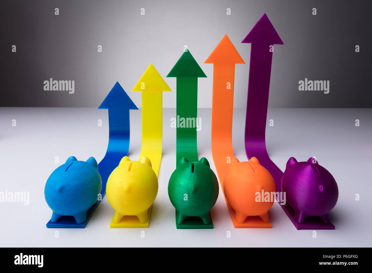 Multi Colored Piggybanks And Increasing Arrows Pointing Upwards Stock Photo