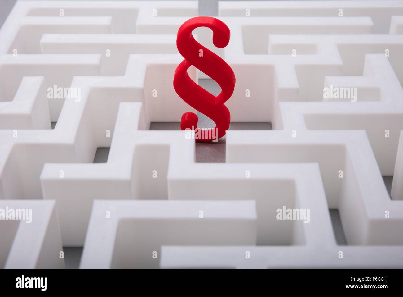 Elevated View Of Red Paragraph Symbol In The Centre Of White Maze Stock Photo