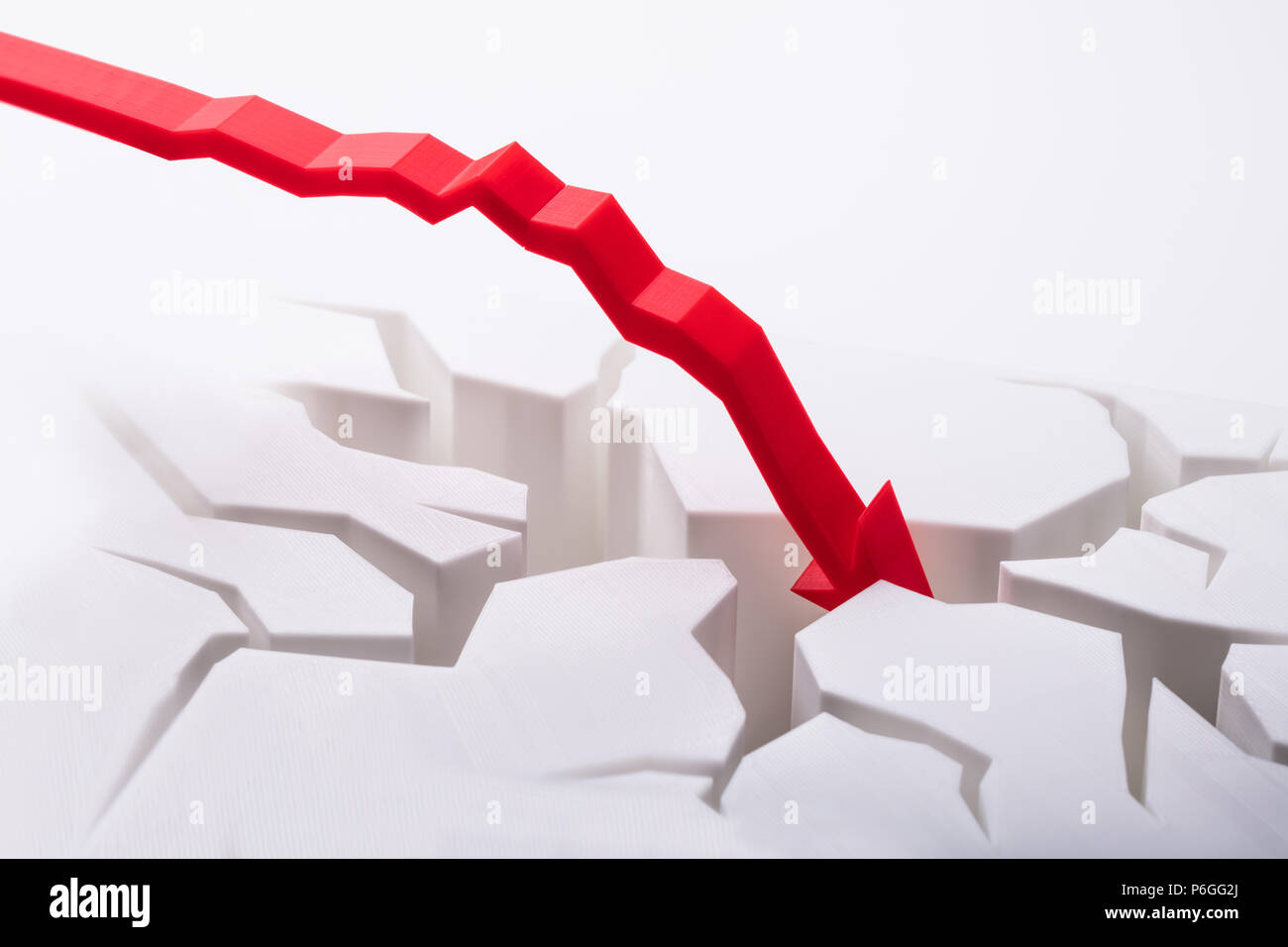 Close-up Of Falling Red Arrow Breaking White Surface Stock Photo