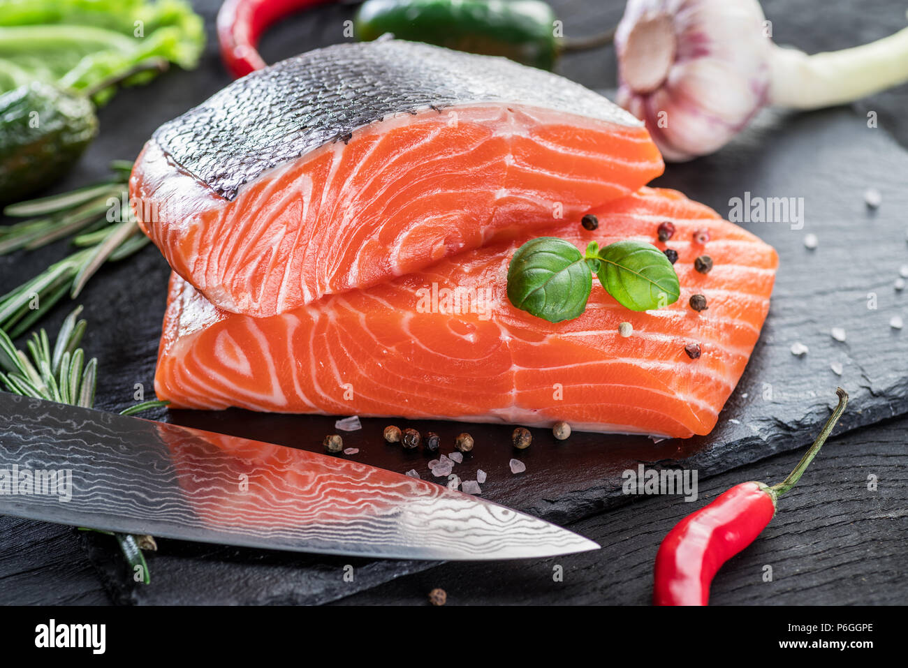 Fresh salmon fillets on black cutting board with herbs and spices Stock ...