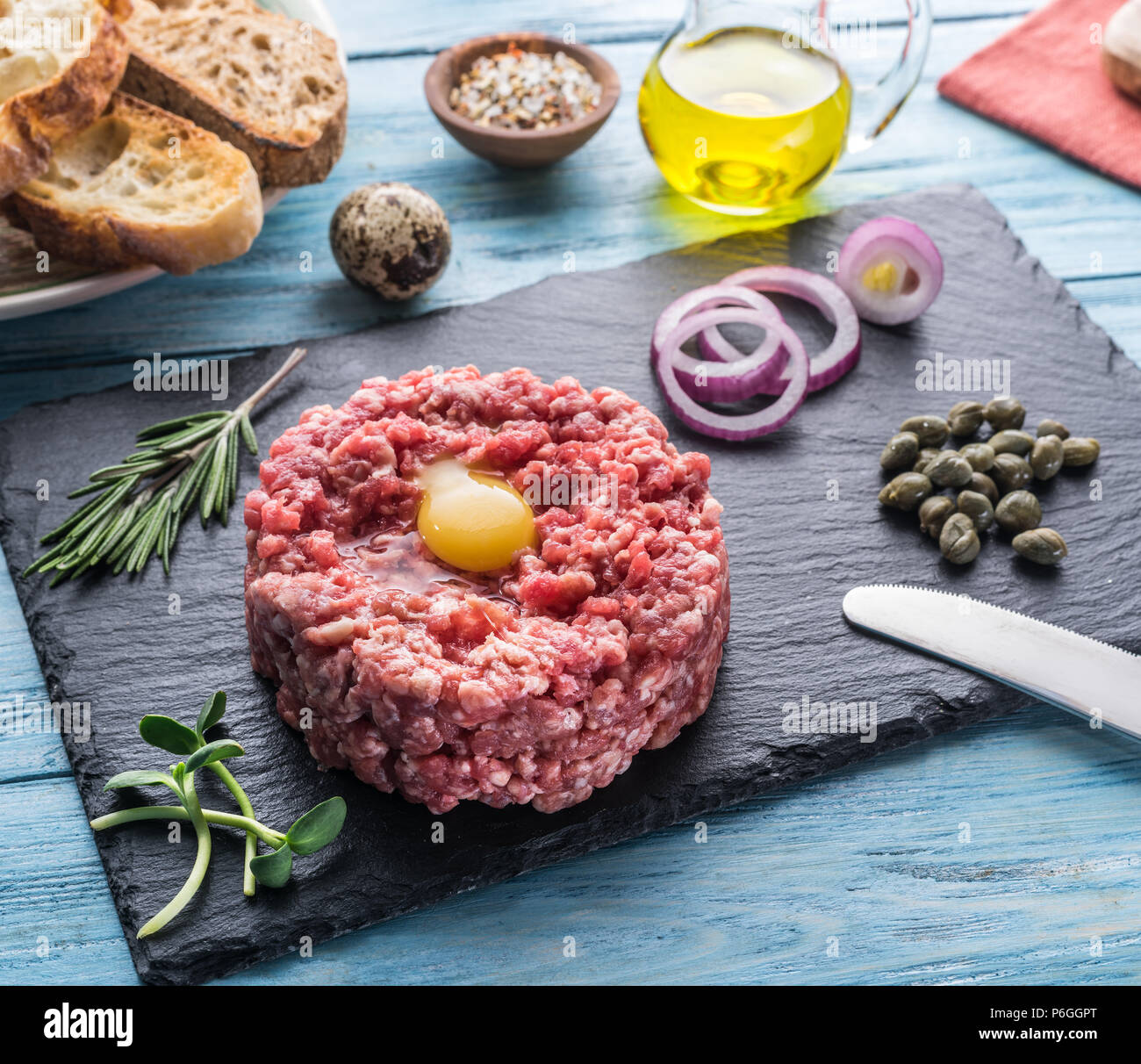 Steak tartare served with raw quail egg yolk, capers and bread. Meat