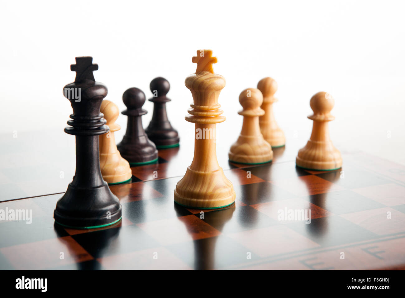 chess duel of two kings and pawns on a white background close up Stock