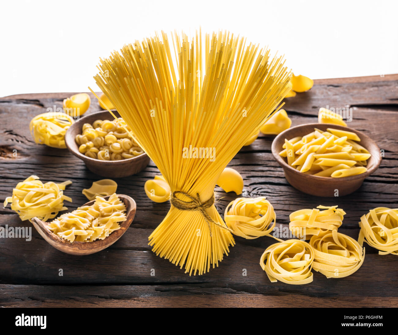 Different pasta types on wooden table. White background. Stock Photo