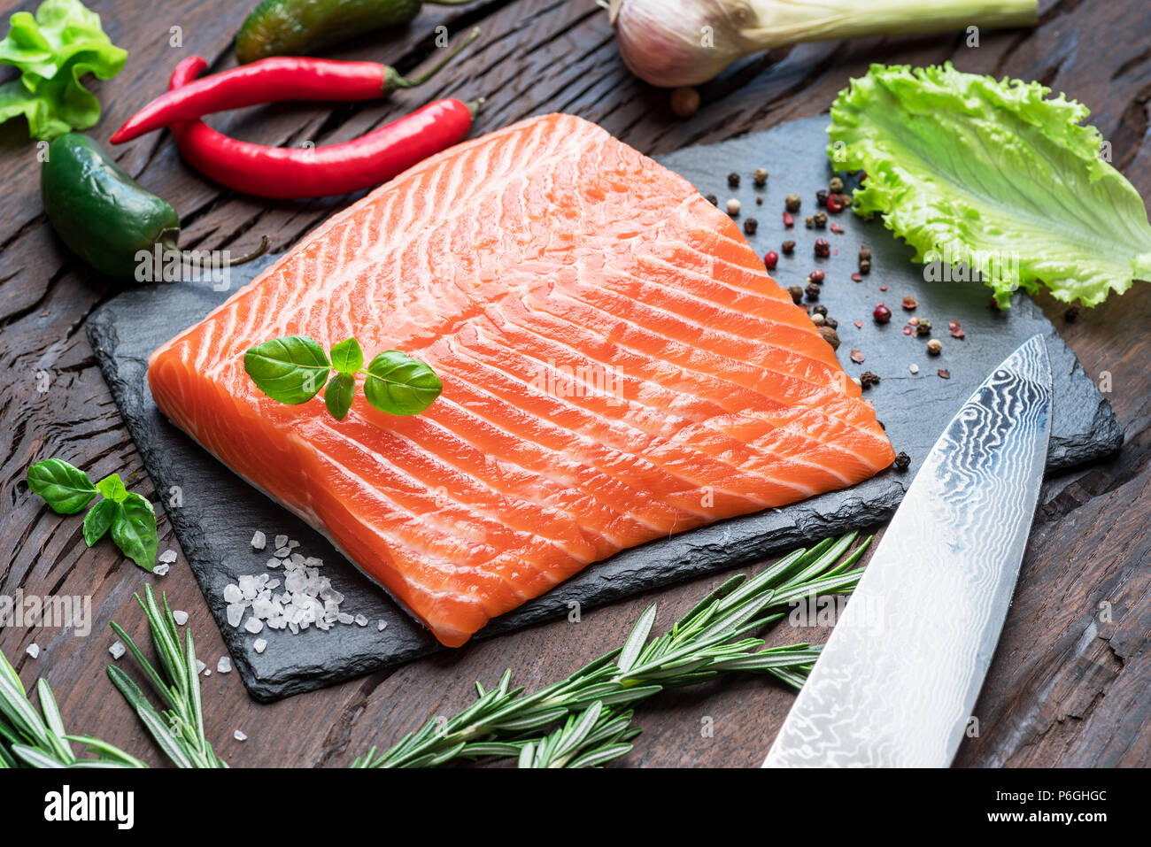 Fresh salmon fillet on black cutting board with herbs and spices Stock ...