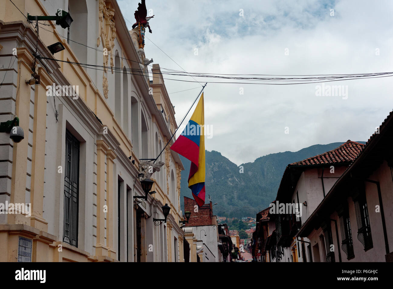 Street scene in central Bogota with national flag and mist covering the monserratte mountain behind, colombia Stock Photo